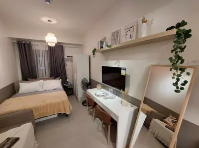 a small bedroom with a bed and a desk in it at 1014 - Cavite Minimalist Condo with Resort-like Amenities & Hi Speed Wifi in Dasmariñas