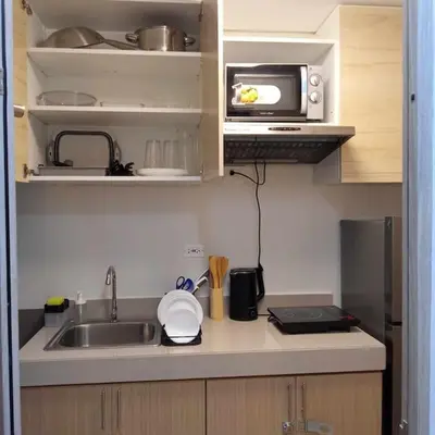 a small kitchen with a sink and a microwave at 1014 - Cavite Minimalist Condo with Resort-like Amenities & Hi Speed Wifi in Dasmariñas