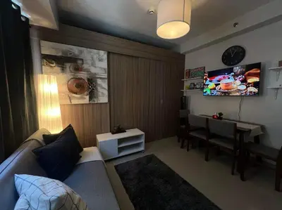 a living room with a couch and a dining table at Shore 2 Residences high speed Internet walking distance to MOA and IKEA in Manila