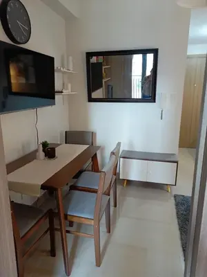a dining room with a table and chairs and a clock at Shore 2 Residences high speed Internet walking distance to MOA and IKEA in Manila