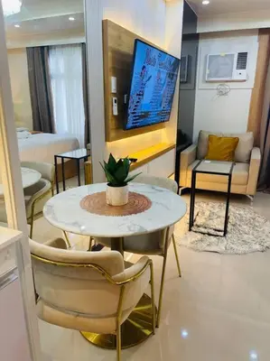 a living room with a table and chairs and a tv at Marias Suite near Manila bay FREE use of Pool in Manila