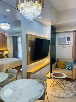a hotel room with a bed and a tv and a bedroom at Marias Suite near Manila bay FREE use of Pool in Manila