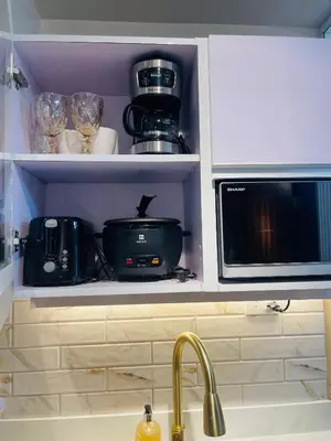 a kitchen cabinet with a microwave and a sink at Marias Suite near Manila bay FREE use of Pool in Manila