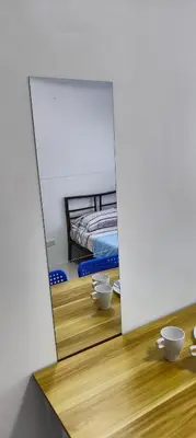 a mirror reflection of a bedroom with a bed in a room at Grand Riviera Suites in Manila