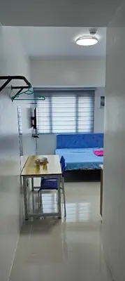 a room with a desk and a bed in a room at Grand Riviera Suites in Manila
