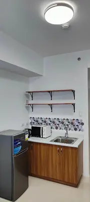a kitchen with a sink and a microwave at Grand Riviera Suites in Manila