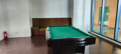 a green pool table in a room with windows at Grand Riviera Suites in Manila