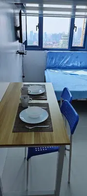 a table with two chairs and a table with plates on it at Grand Riviera Suites in Manila