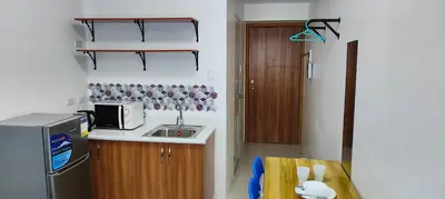 a small kitchen with a sink and a refrigerator at Grand Riviera Suites in Manila