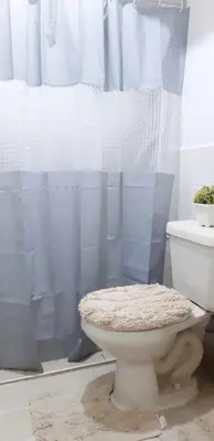a bathroom with a toilet and a blue shower curtain at WNSuites in Manila