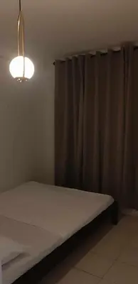 a room with a bed with a curtain and a light at WNSuites in Manila