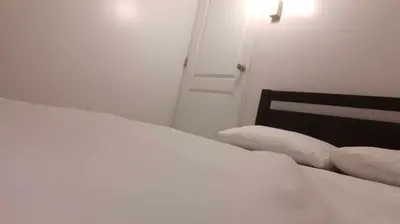 a white bed with two pillows on it in a bedroom at WNSuites in Manila