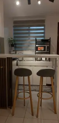 a kitchen with two stools and a counter with a microwave at WNSuites in Manila