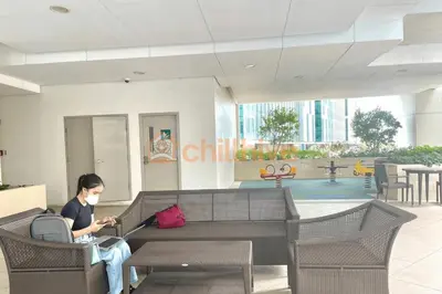 a woman sitting on a couch in a building at Prime BGC Condo: Uptown Mall & Hyatt #ournw21n in Manila