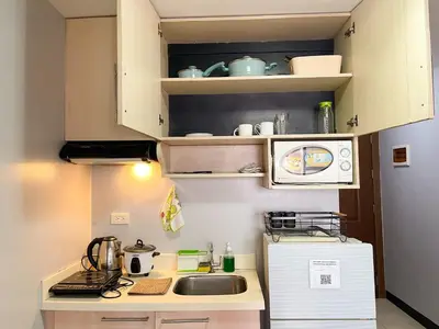 a small kitchen with a sink and a refrigerator at Cozy & Affordable Stay Near Bgc #rt33005 in Manila