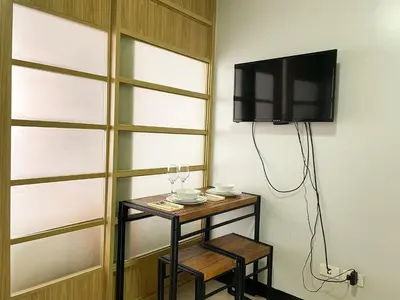 a room with a table with a tv on a wall at Cozy & Affordable Stay Near Bgc #rt33005 in Manila