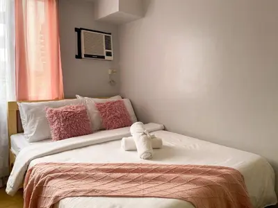 a bedroom with two beds with pink and white pillows at Cozy & Affordable Stay Near Bgc #rt33005 in Manila