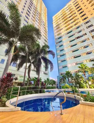 a swimming pool with palm trees and tall buildings at Affordable Condo Near Bgc, Venice Mall #rt33006 in Manila