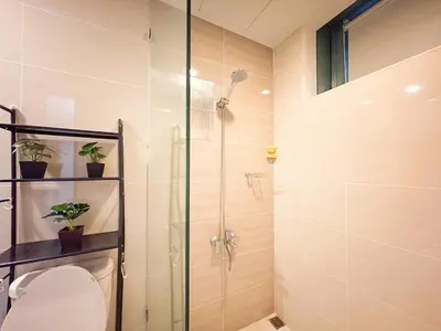 a bathroom with a toilet and a glass shower at Prime BGC Condo at Uptown Area #oursw11g in Manila