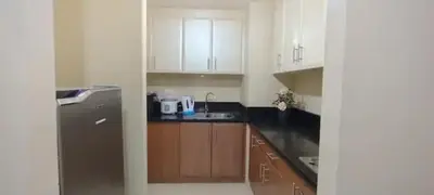 a kitchen with white cabinets and a black refrigerator at 1Bedroom Accommodation Near Airport in Manila