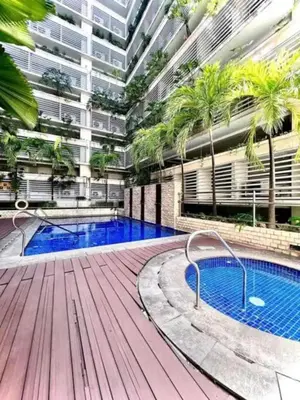 a large building with a swimming pool with palm trees at 1Bedroom Accommodation Near Airport in Manila