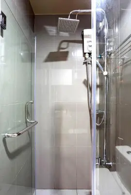 a shower with a glass door in a bathroom at COZY SKYLINE CONDO in MAKATI in Manila