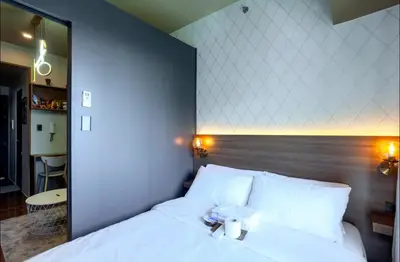 a bed with a teddy bear sitting on top of it at COZY SKYLINE CONDO in MAKATI in Manila
