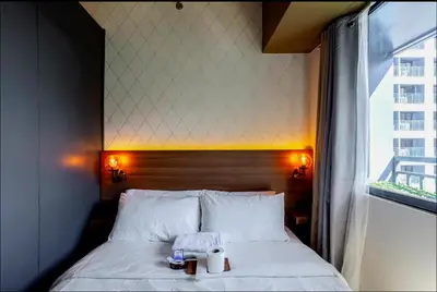 a bed with a stuffed elephant on top of it at COZY SKYLINE CONDO in MAKATI in Manila