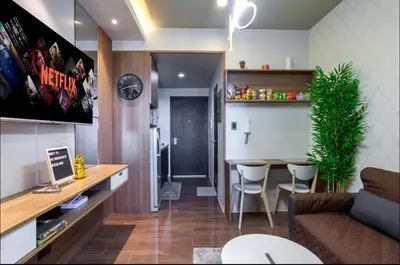 a living room with a couch and a table with chairs at COZY SKYLINE CONDO in MAKATI in Manila