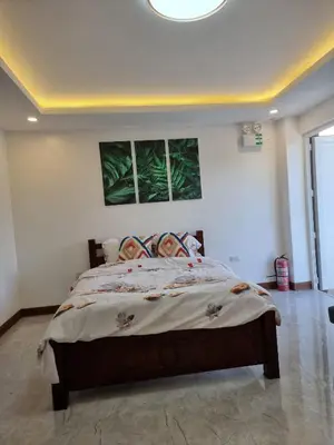 a bedroom with a bed with two paintings on the wall at B Mary's Staycation in Tanza CAVITE Condo Type with balcony 2 person in Tanza