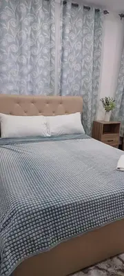 a bedroom with a bed with a blue and white wall at B Mary's Staycation in Tanza CAVITE Condo Type with balcony 2 person in Tanza