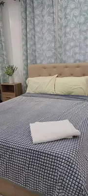 a bed with a white pillow on top of it at B Mary's Staycation in Tanza CAVITE Condo Type with balcony 2 person in Tanza