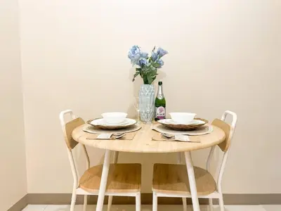 a wooden table with two chairs and a vase of flowers at Premium BGC 1BR Near Grand Hyatt #upt119h in Manila