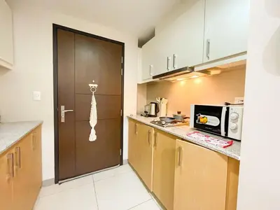a kitchen with a door leading into a kitchen with a microwave at Premium BGC 1BR Near Grand Hyatt #upt119h in Manila