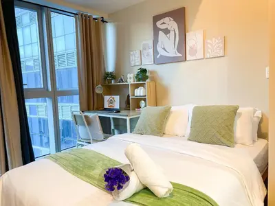 a bedroom with a large white bed with a desk at Premium BGC 1BR Near Grand Hyatt #upt119h in Manila