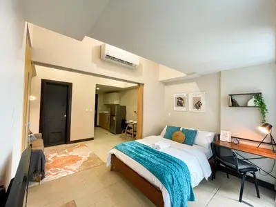 a bedroom with a bed and a desk in it at BGC Condo Facing Mitsukoshi Mall #upt122g in Manila