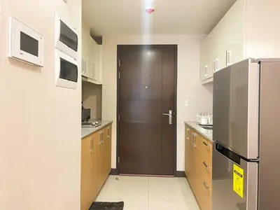 a kitchen with a brown door and a refrigerator at BGC Condo Facing Mitsukoshi Mall #upt122g in Manila