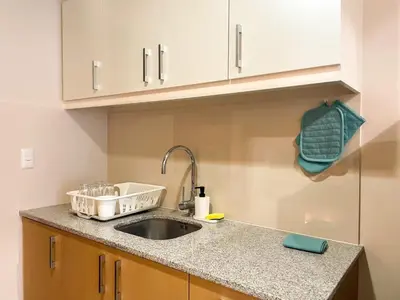 a kitchen counter with a sink and a green towel at BGC Condo Facing Mitsukoshi Mall #upt122g in Manila