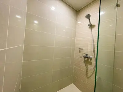 a shower with a glass door in a bathroom at Chic BGC Condo Near Uptown Parade #upt124r in Manila