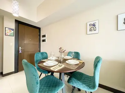 a dining room with a table and blue chairs at Chic BGC Condo Near Uptown Parade #upt124r in Manila
