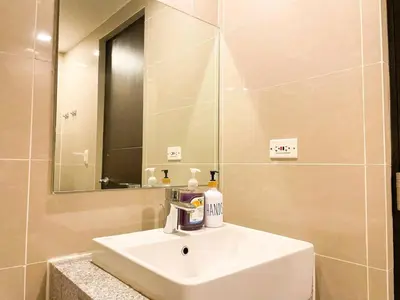 a bathroom with a white sink and a mirror at Luxurious Modern BGC Condo at Uptown #upt131h in Manila