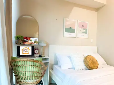 a bedroom with a bed and a desk with a laptop at Luxurious Modern BGC Condo at Uptown #upt131h in Manila