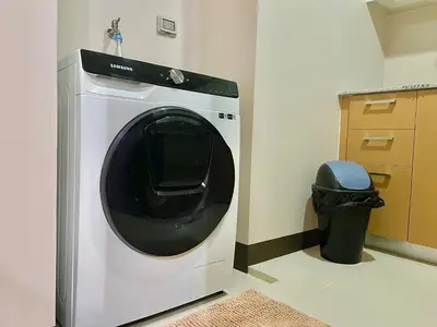 a white washing machine in a room with a trash can at Prime BGC Condo Near Grand Hyatt #upt131q in Manila