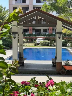 a gazebo with a pool in front of a building at 2-bedroom with Balcony in a Resort Setting - H Ivory in Manila