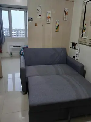 a living room with a blue couch in a room at BLUE sea Residences in Manila