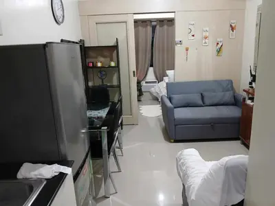 a living room with a couch and a tv at BLUE sea Residences in Manila