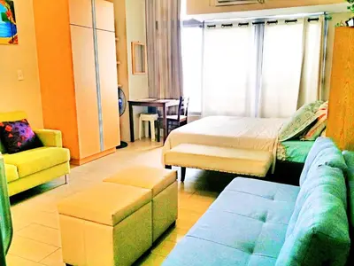 a living room with a bed and a couch at Eastwood Legrand Tower 3 condominium in Manila