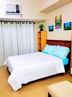 a bedroom with a white bed and a window at Eastwood Legrand Tower 3 condominium in Manila