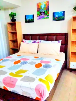 a bedroom with a bed with a colorful comforter at Eastwood Legrand Tower 3 condominium in Manila