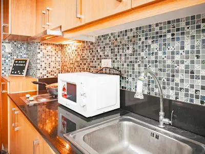 a kitchen with a sink and a microwave at 633 Air Condo Pool View Escape Cozy 1BR w Sofa Bed in Manila
